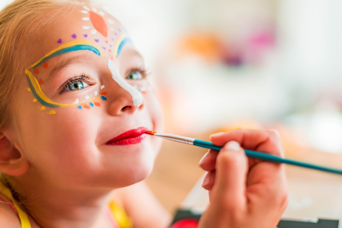 A child gets her face painted during a family event.