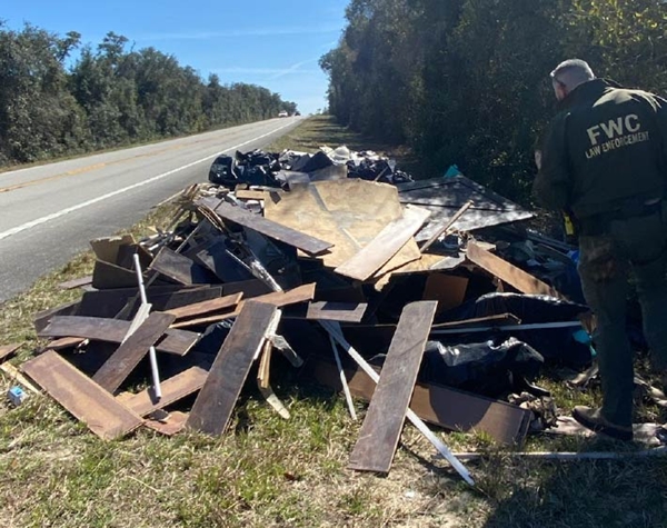 FWC Officer Constance examines 5,240 pounds of litter found along State Road 19. HIs investigation led to an arrest in Orange County.