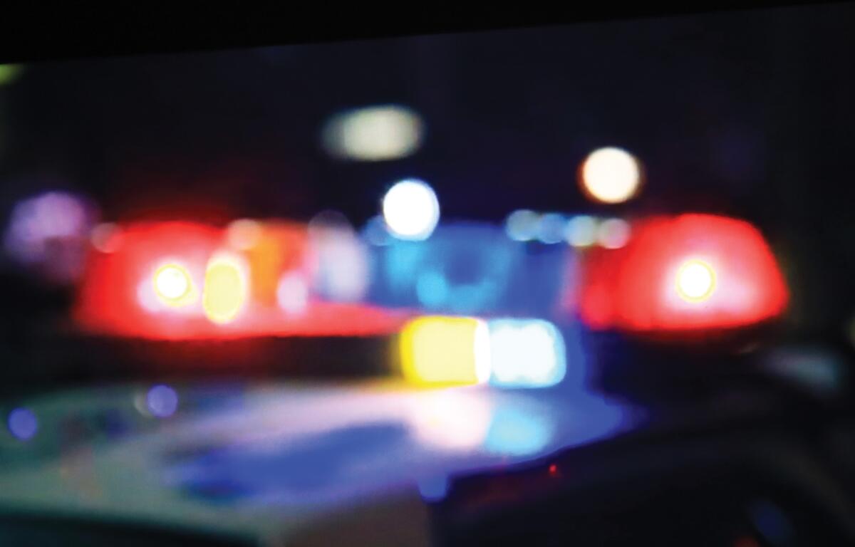 Blurred red and blue police lights glowing in the dark during a nighttime emergency response.