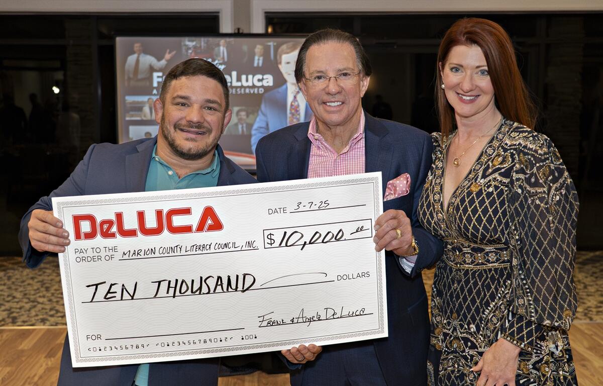 RJ Jenkins of the Marion County Literacy Council (left) receives a $10,000 donation from philanthropists Frank and Angela DeLuca during a retirement celebration on March 7, 2025, in Ocala, FL. The contribution will help fund literacy programs for adults in the community.