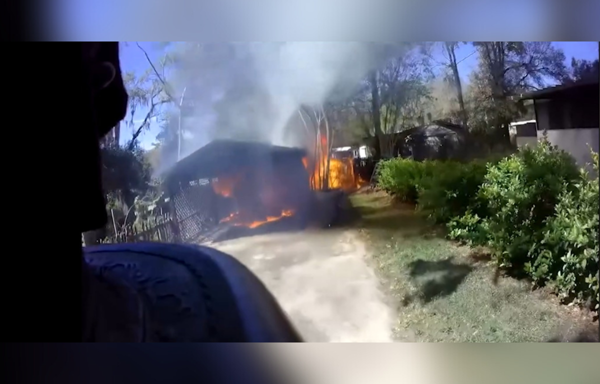 Firemen battle off a blaze as it engulfs a small shed.