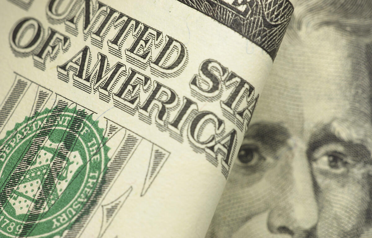 Close-up of a rolled U.S. $50 bill showing partial text and President Grant’s face.