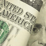 Close-up of a rolled U.S. $50 bill showing partial text and President Grant’s face.