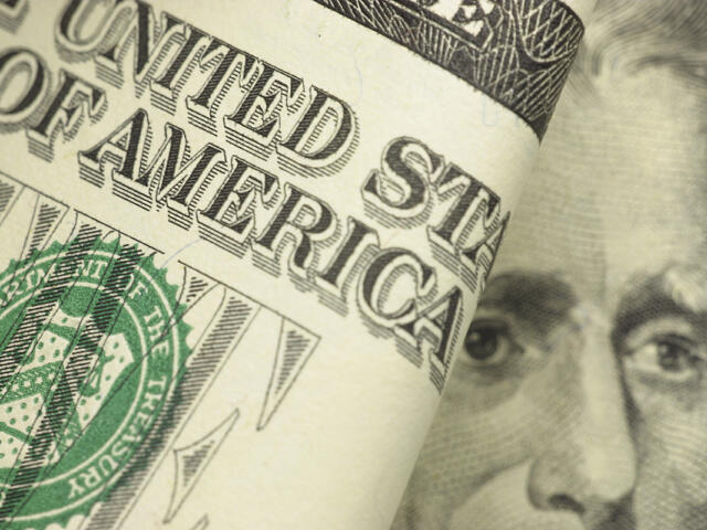 Close-up of a rolled U.S. $50 bill showing partial text and President Grant’s face.