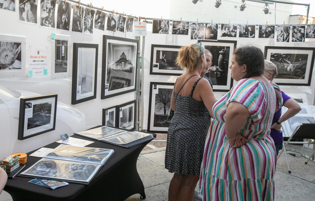 Visitors check out Phillip D. Breske’s photography downtown during First Friday Art Walk in Ocala, FL on Friday, April 4, 2025.