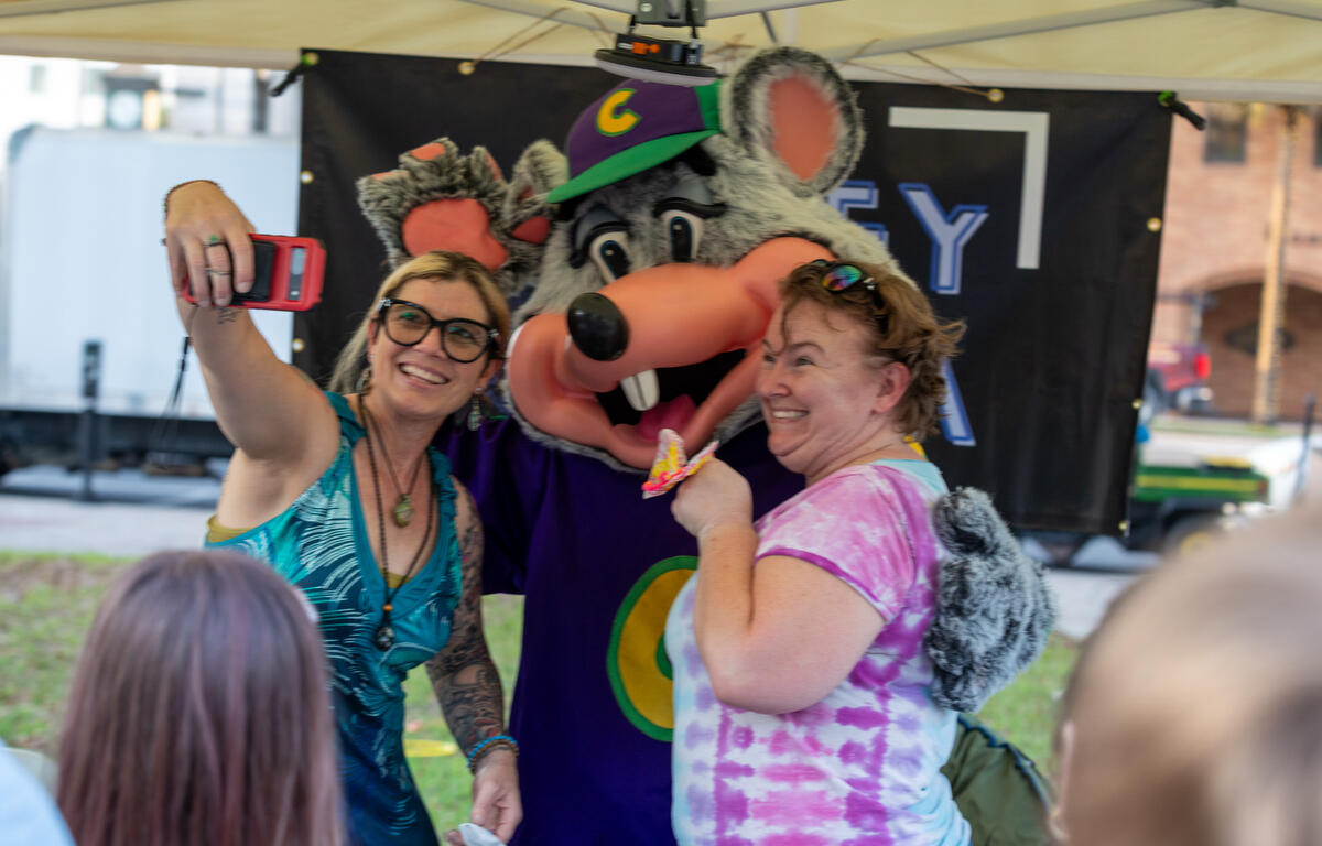 Darian Mosley, left, and Stevie Bryant grab a selfie with Chuck E. Cheese downtown during First Friday Art Walk in Ocala, FL on Friday, April 4, 2025.