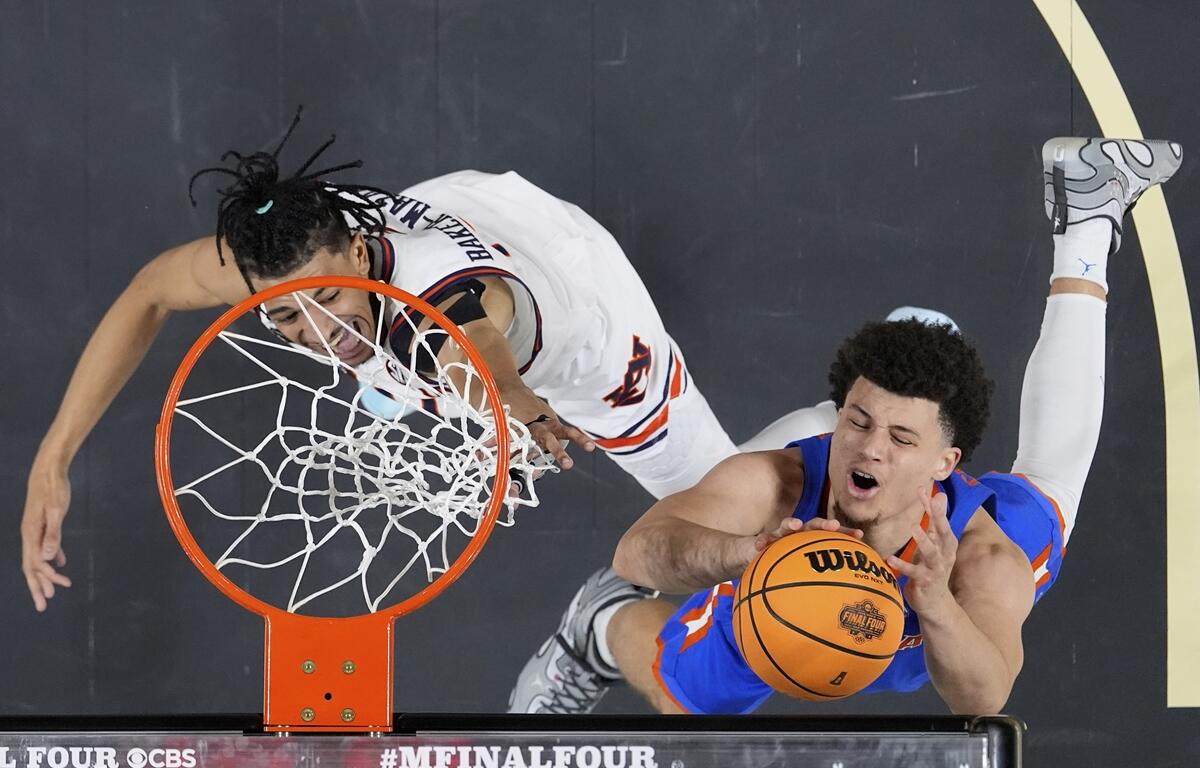 Auburn guard Chad Baker-Mazara vies for the ball with Florida guard Walter Clayton Jr. during the first half in the national semifinals at the Final Four of the NCAA college basketball tournament, Saturday, April 5, 2025, in San Antonio.