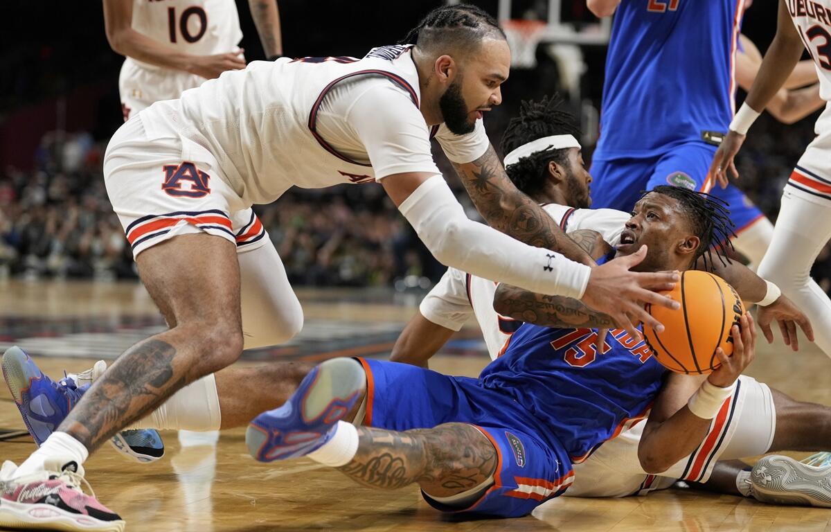Auburn forward Johni Broome vies for the ball with Florida guard Alijah Martin during the second half in the national semifinals at the Final Four of the NCAA college basketball tournament, Saturday, April 5, 2025, in San Antonio.