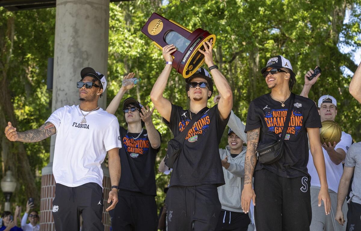 Florida guard Walter Clayton Jr. holds up the trophy as the team arrives at the University of Florida after winning the NCAA national basketball championship, Tuesday, April 8, 2025, in Gainesville, FL.
