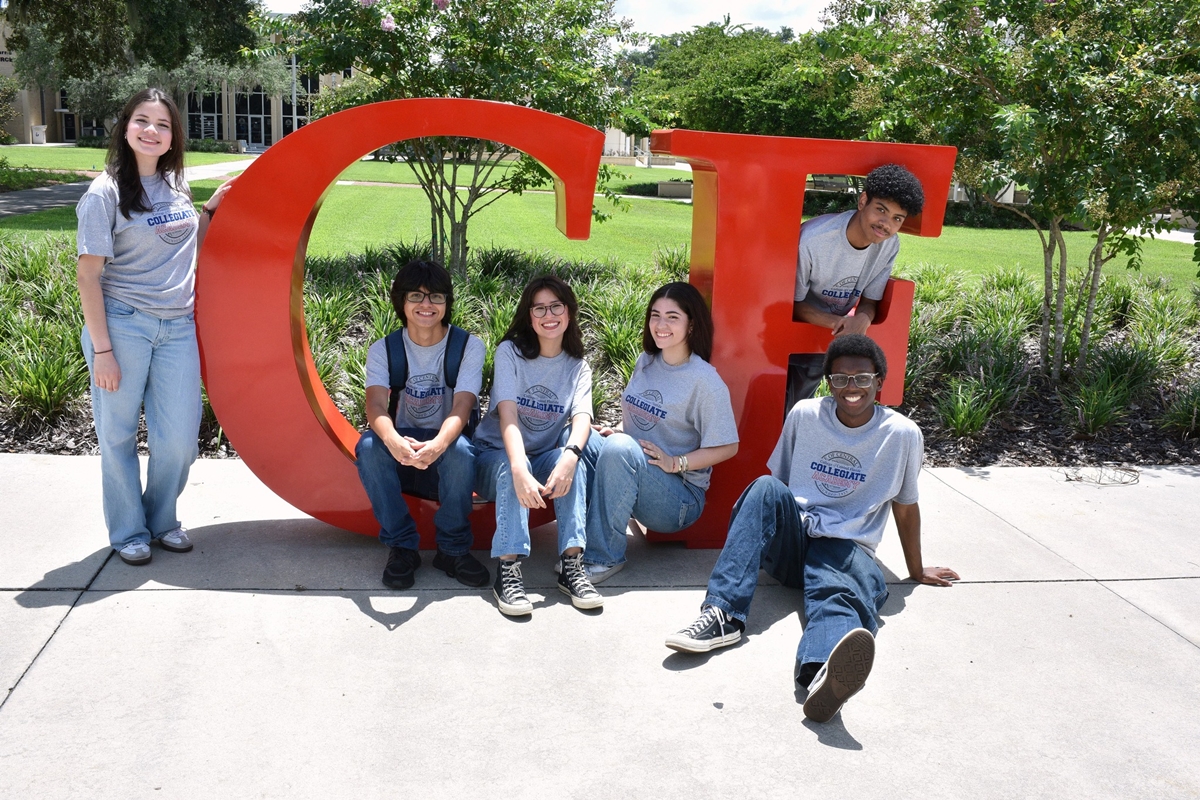 Students from the CF Collegiate Academy pose by the large CF letters on the College of Central Florida Ocala Campus. The academy allows high school students to earn college credits while completing their diploma.