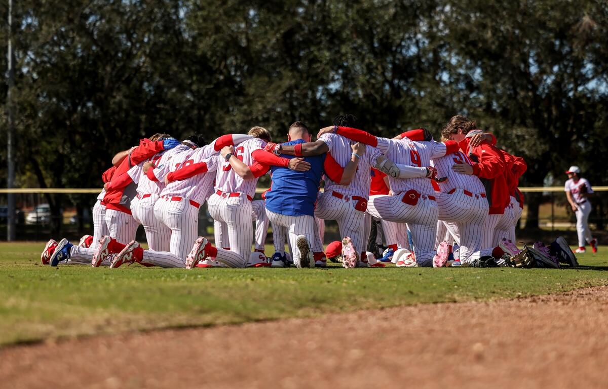 The College of Central Florida baseball team huddles on the field before their game.