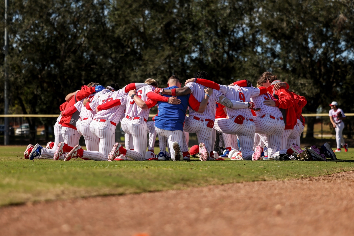 The College of Central Florida baseball team huddles on the field before their game.