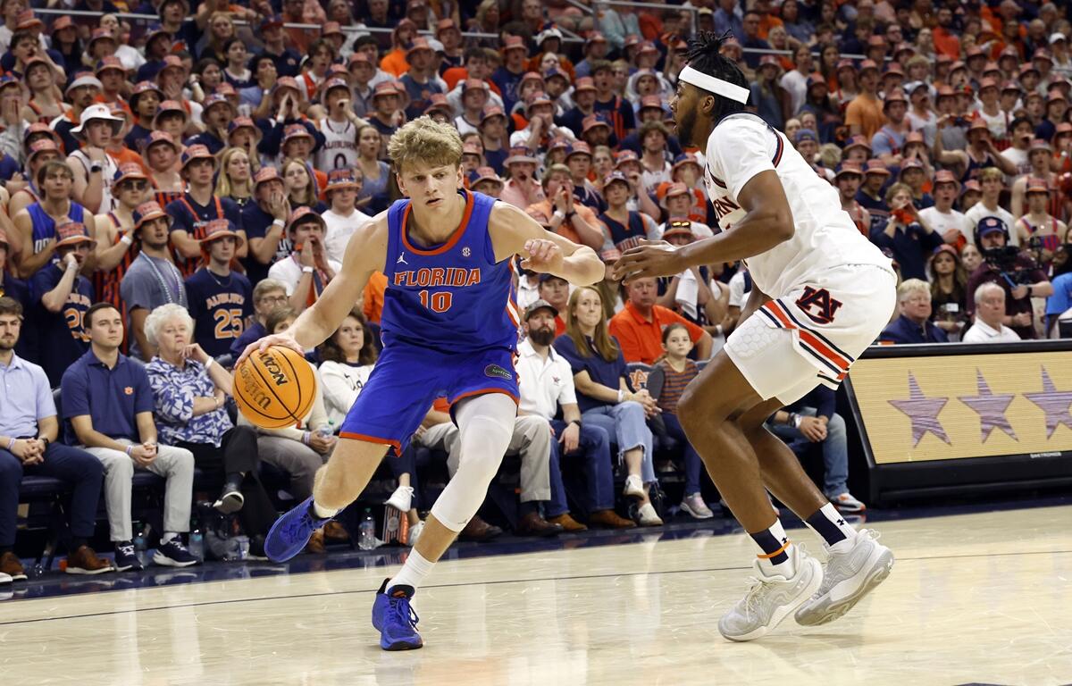 Florida forward Thomas Haugh (10) dribbles around Auburn forward Chaney Johnson, right, during the first half of an NCAA college basketball game, Saturday, Feb. 8, 2025, in Auburn, AL.