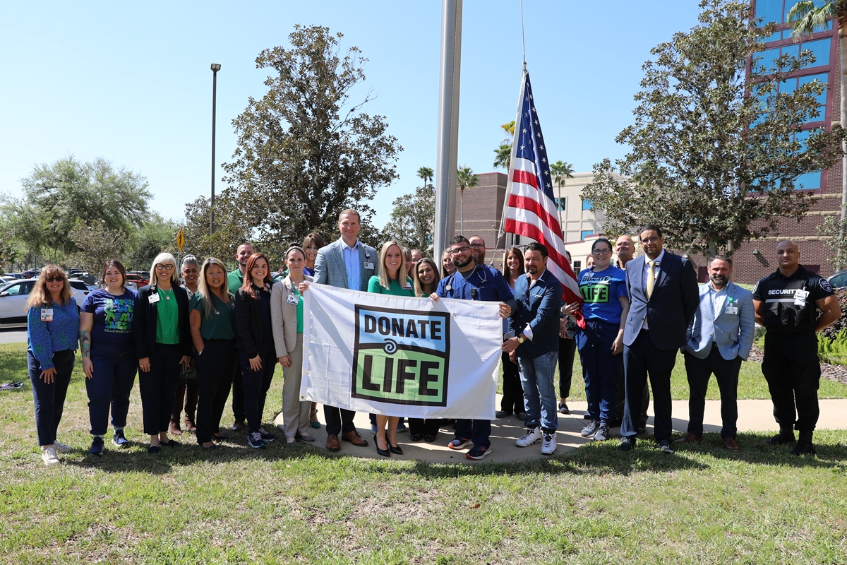 Staff and community members gather for a flag-raising ceremony at HCA Florida Ocala Hospital in honor of National Donate Life Month.