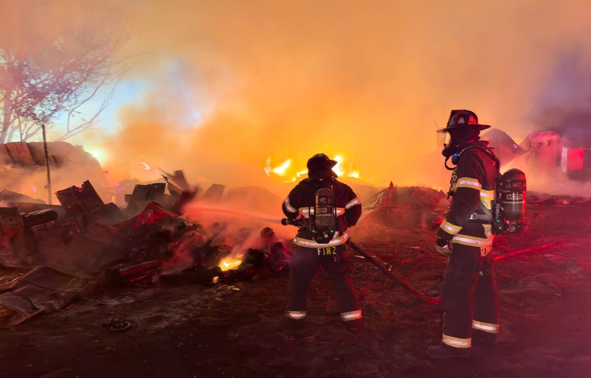 Marion County firefighters work to contain a structure fire near SE 127th Lane in Belleview on April 3, 2025. The blaze spread into nearby woods and caused parts of the building to collapse. No injuries were reported.