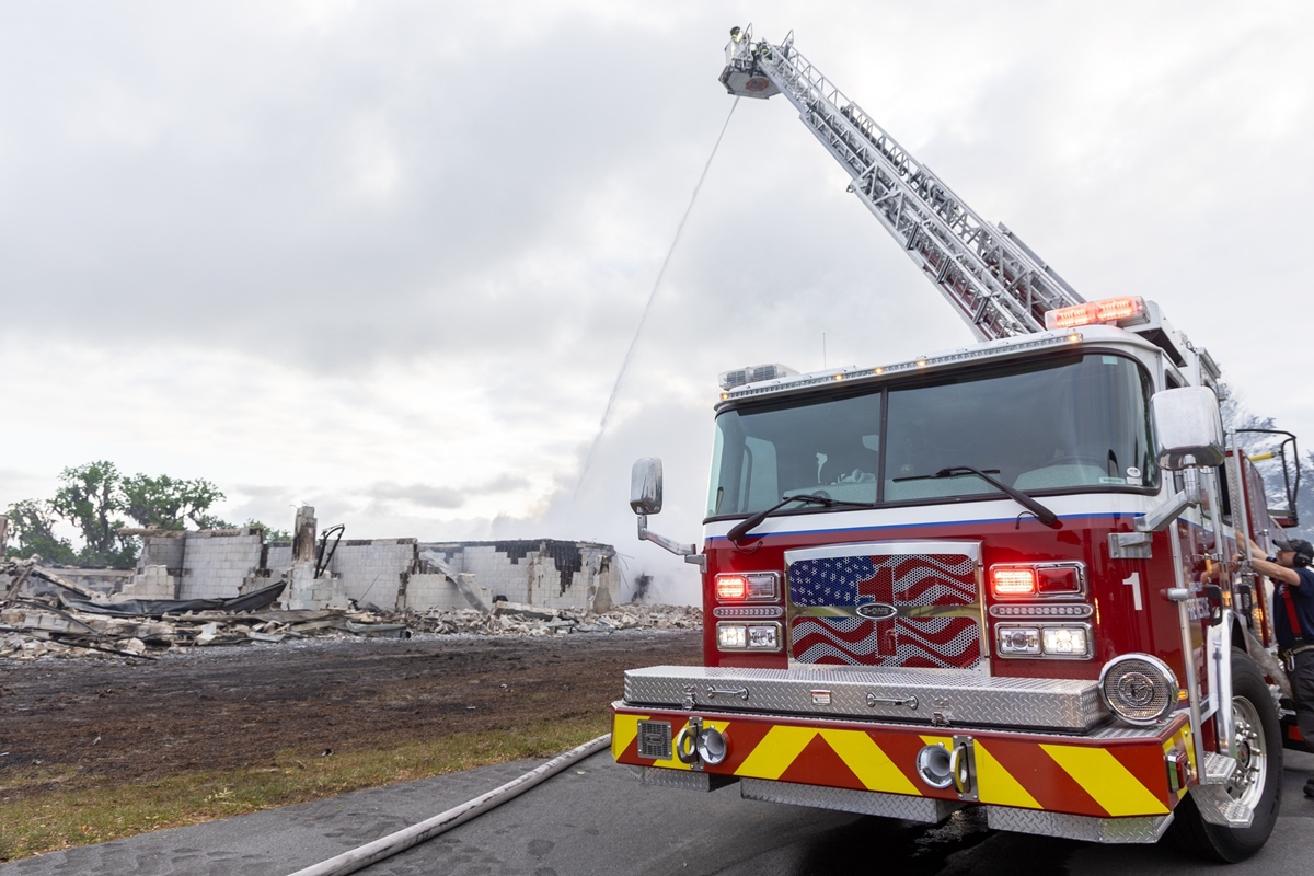 A Marion County Fire Rescue engine sprays water over the smoldering remains of a barn in Reddick, Fla., on Monday, April 8, 2024. The early morning fire destroyed the structure and killed 21 horses. The cause is under investigation.