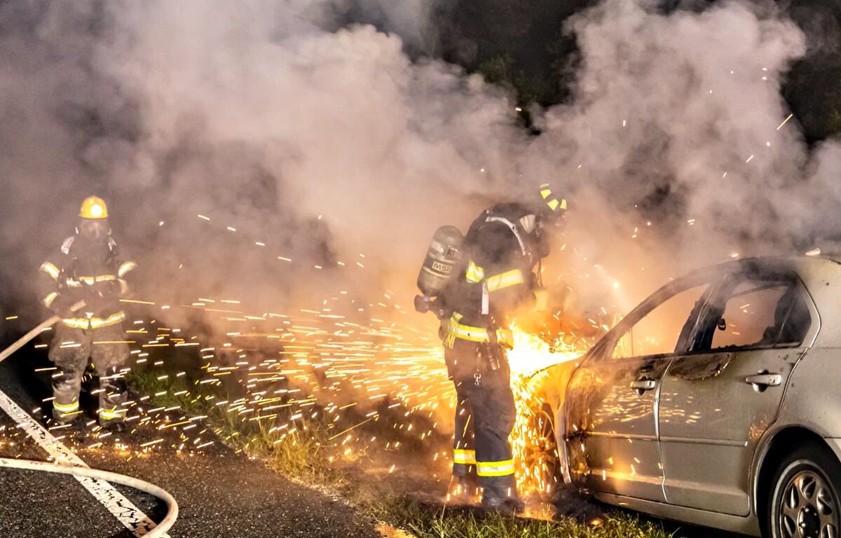 A Marion County Fire Rescue firefighter uses a saw to cut into a burned vehicle as another crew member stands by early Tuesday, April 9, 2024, after extinguishing a fire off East Highway 40. No injuries were reported.