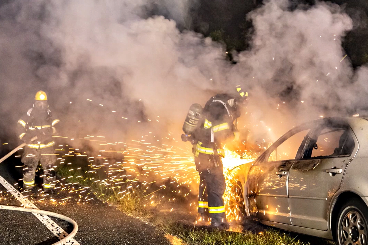 A Marion County Fire Rescue firefighter uses a saw to cut into a burned vehicle as another crew member stands by early Tuesday, April 9, 2024, after extinguishing a fire off East Highway 40. No injuries were reported.
