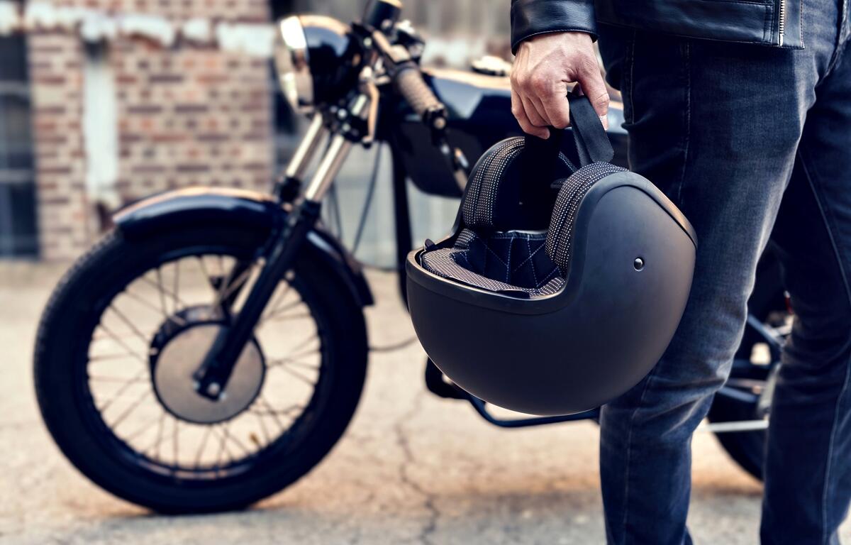 A motorcyclist holds a helmet beside a parked motorcycle in Ocala. Local police are increasing traffic enforcement through September to improve motorcycle safety.