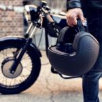 A motorcyclist holds a helmet beside a parked motorcycle in Ocala. Local police are increasing traffic enforcement through September to improve motorcycle safety.