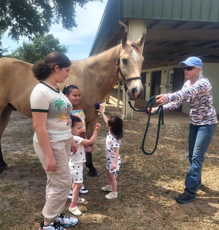 Jaqui deMeric shares her horse, Rocket, with some of the children. Planting seeds.... sharing the magic of the horse.