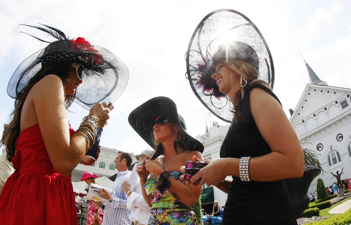 Photo of three women in spectator hats at the Kentucky Derby.