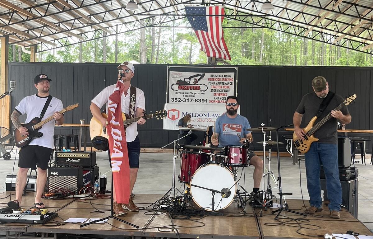 Band playing live music on stage under pavilion at BBQ & Brew Festival in Williston
