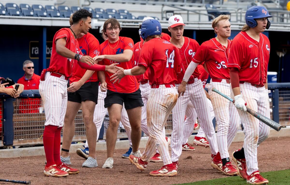 College of Central Florida baseball players in red jerseys celebrate near the dugout during the Region 8 Championship game in Port Charlotte.