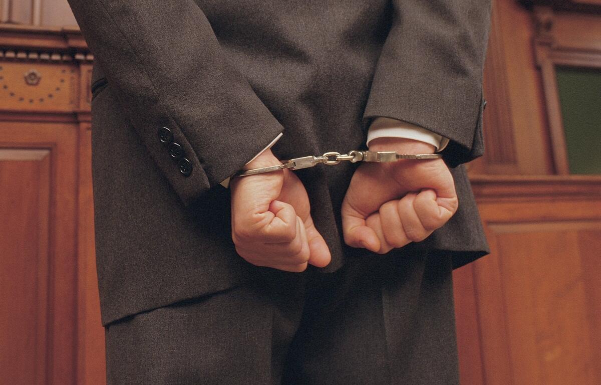 Businessman in handcuffs faces judge in court