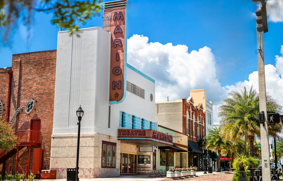 Exterior view of the Marion Theatre in downtown Ocala, featuring its retro marquee and art deco design on a sunny day.