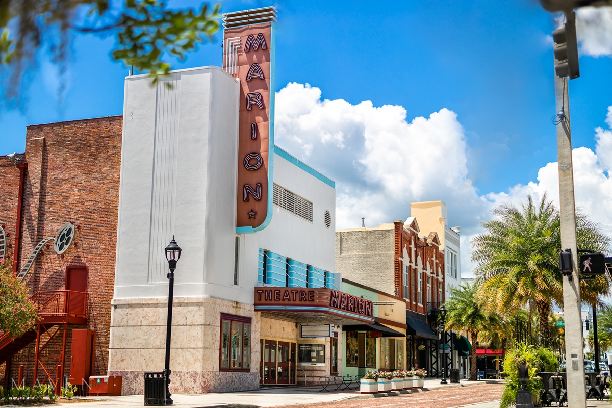 Exterior view of the Marion Theatre in downtown Ocala, featuring its retro marquee and art deco design on a sunny day.