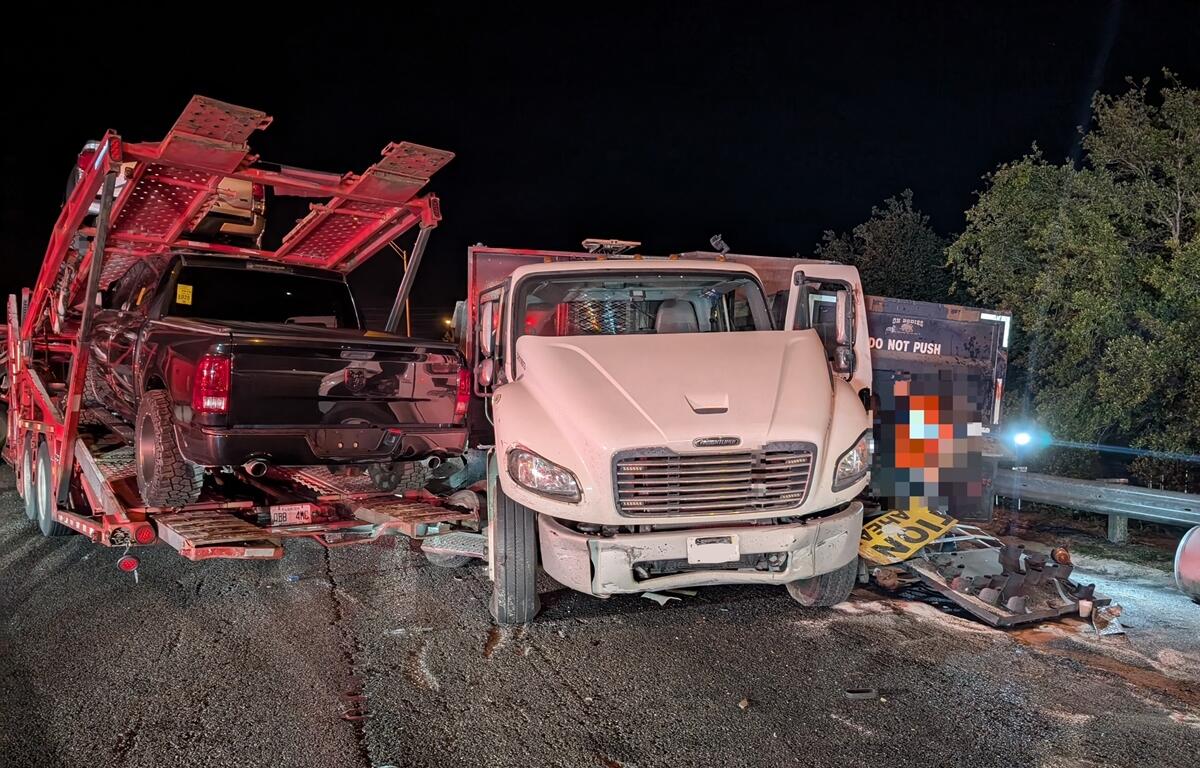 Front view of a damaged work truck and car hauler involved in a multi-vehicle crash on I-75 in Ocala at night.