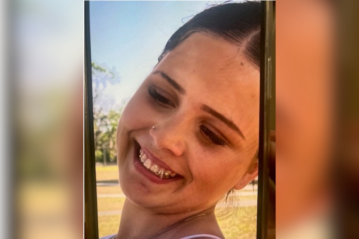 Close-up photo of Elizabeth Fulmer smiling outdoors, showing braces and wearing a nose stud.