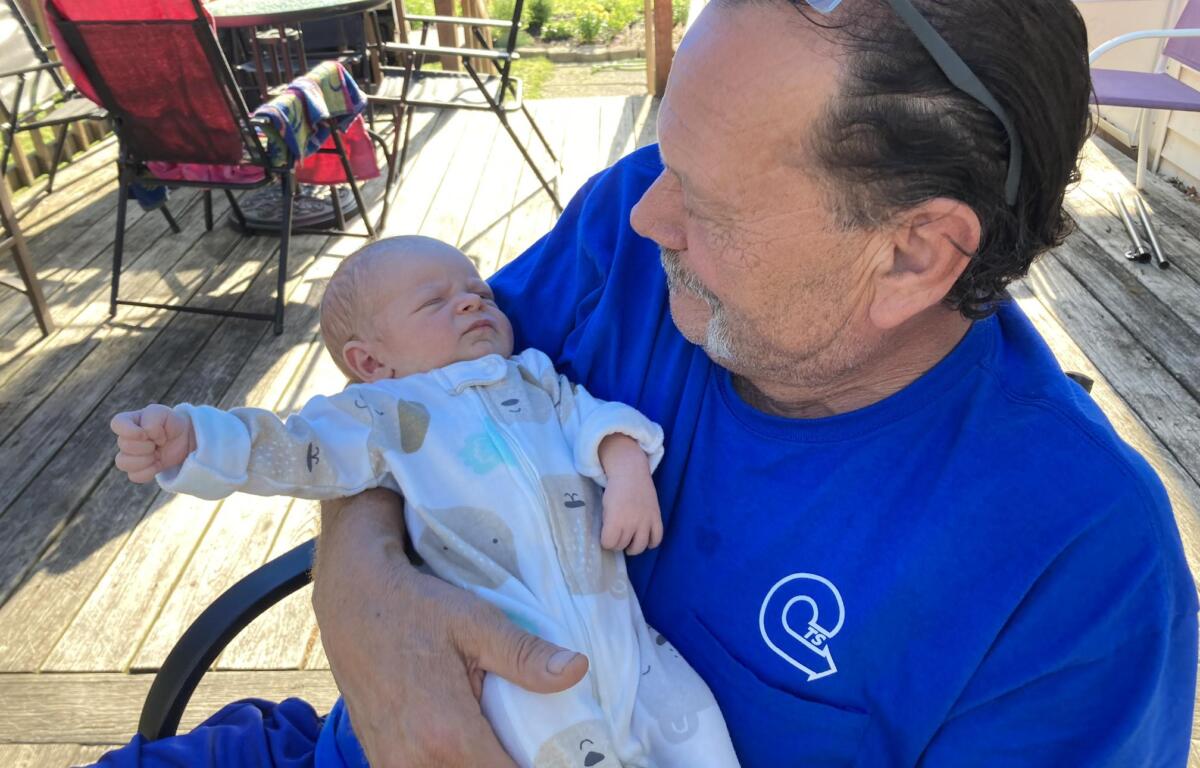 Don wears a blue shirt as he holds his grandson, Cameron, who is wearing blue pajamas
