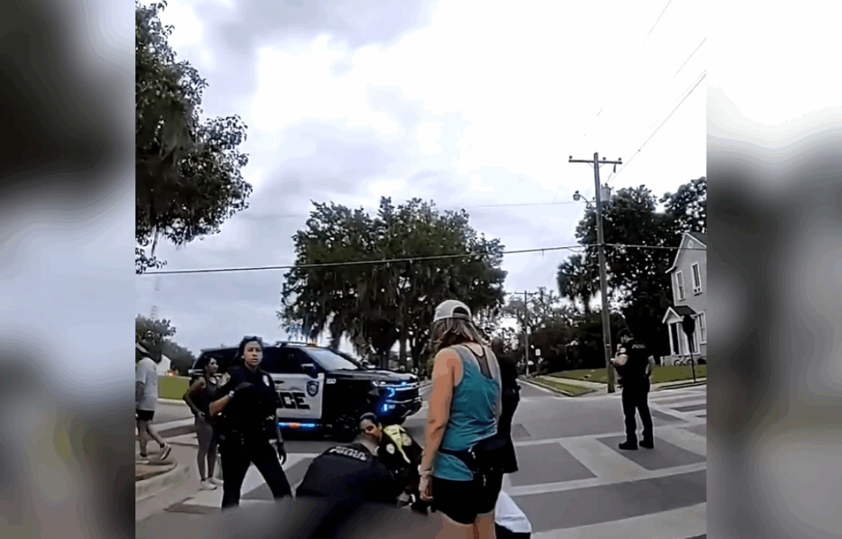Body cam footage captures a lady in a blue shirt and fellow officers with black uniforms helping out a collapsed man.