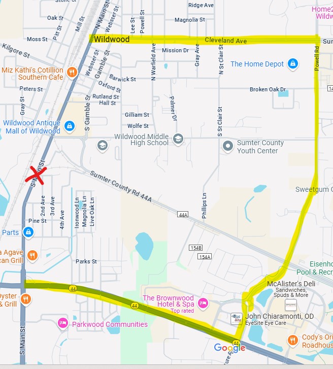 A street map of Wildwood, Florida, highlighting an alternate detour route in yellow around a road closure on U.S. 301 at Switcher Street. The detour follows Cleveland Avenue (C.R. 466A) east to Powell Road, then south to State Road 44, avoiding nearby school zones such as Wildwood Middle High School. The closed railroad crossing is marked with a red X.