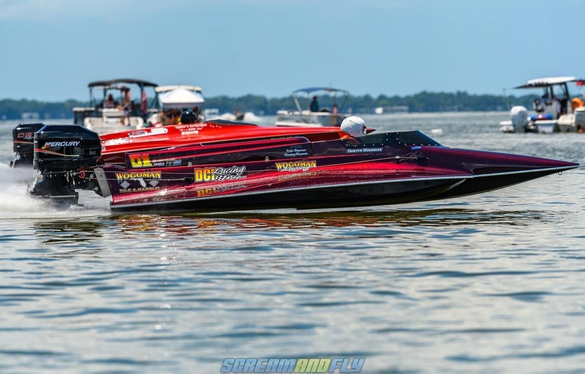 Two drag boats race on Lake Eustis with onlookers watching from surrounding boats during the Summer Showdown event.