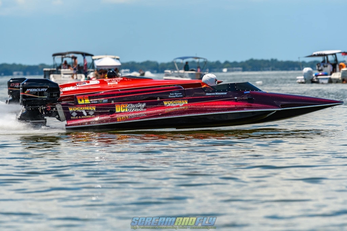 Two drag boats race on Lake Eustis with onlookers watching from surrounding boats during the Summer Showdown event.