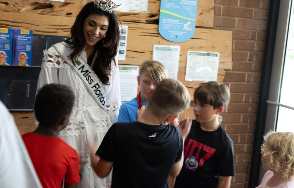 Miss Florida talking with a group of children indoors at Silver Springs.