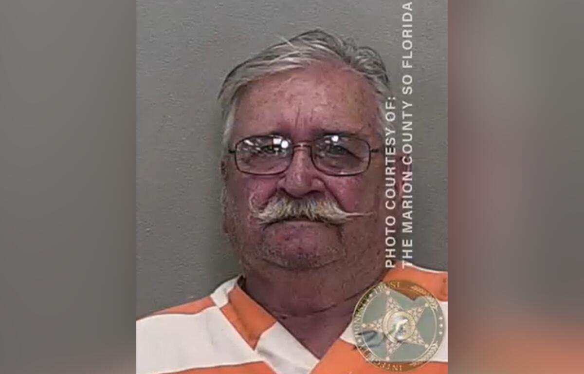 Mugshot of Allen Svilhik wearing an orange and white jail uniform.