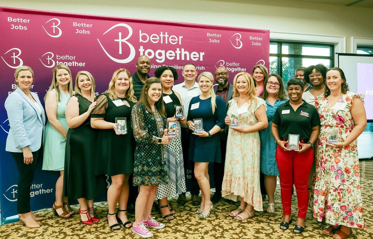 Group photo of Better Together staff and award winners standing in front of a Better Together banner during the Ocala awards reception.