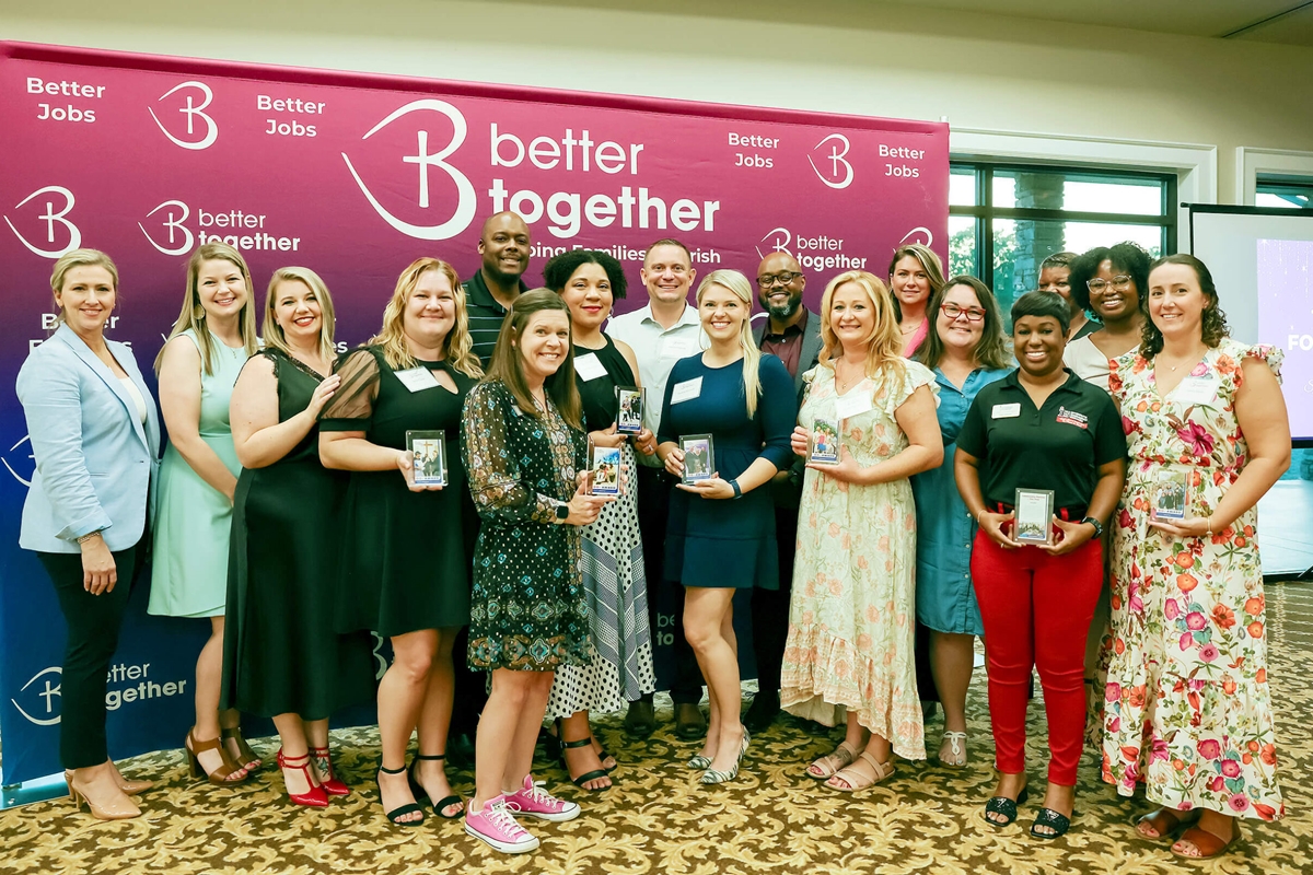 Group photo of Better Together staff and award winners standing in front of a Better Together banner during the Ocala awards reception.