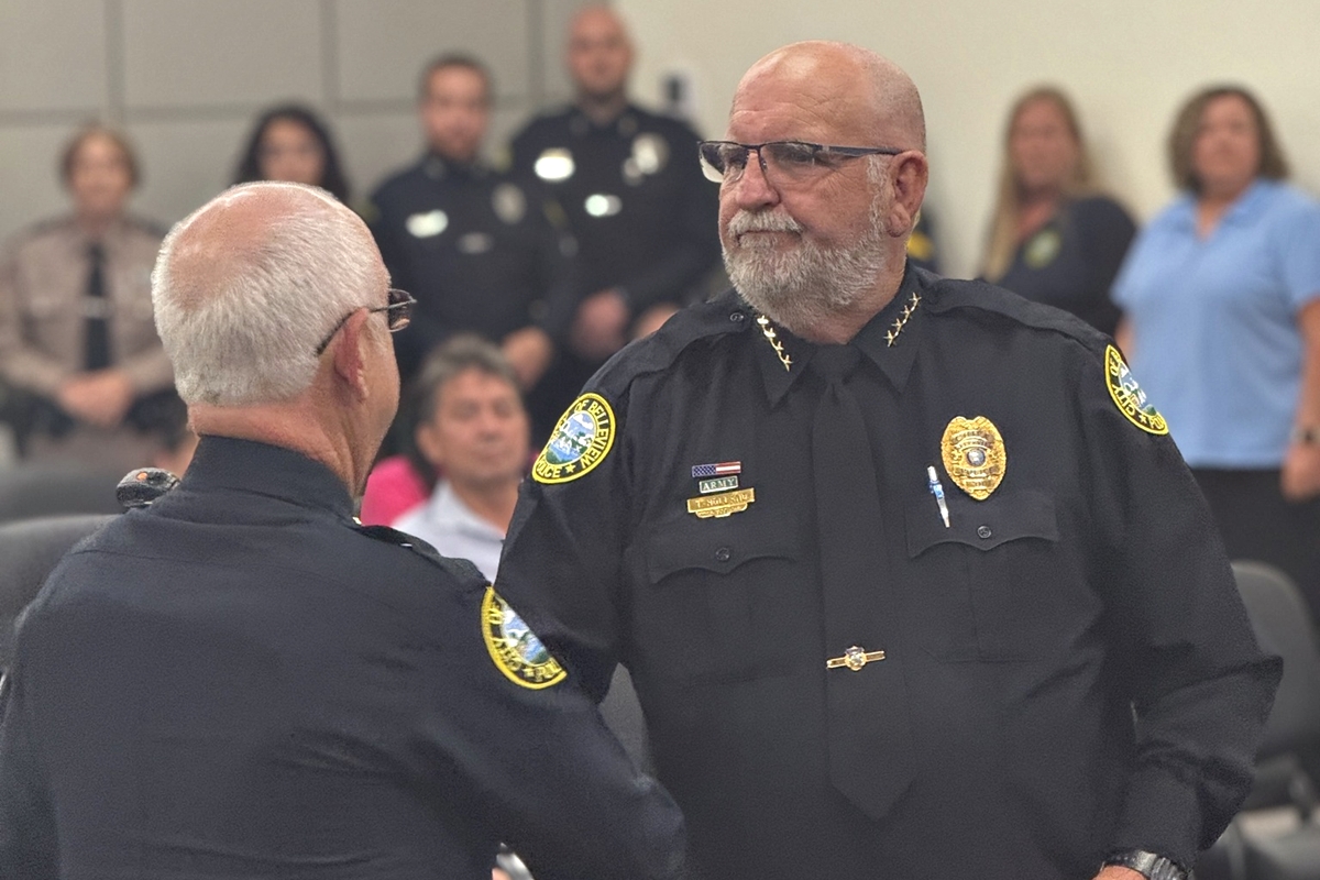 Belleview Police Chief Terry Holland shakes hands with Assistant Chief Larry Bryan during a promotion ceremony at the Belleview City Commission meeting.