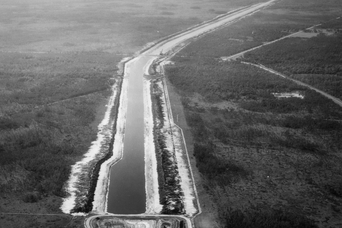 Aerial view of a partially constructed section of the Cross Florida Barge Canal cutting through forested land in central Florida.