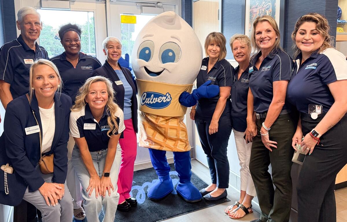 Group photo of Ocala CEP staff and Culver’s employees smiling with mascot Scoopie inside the new Culver’s restaurant.