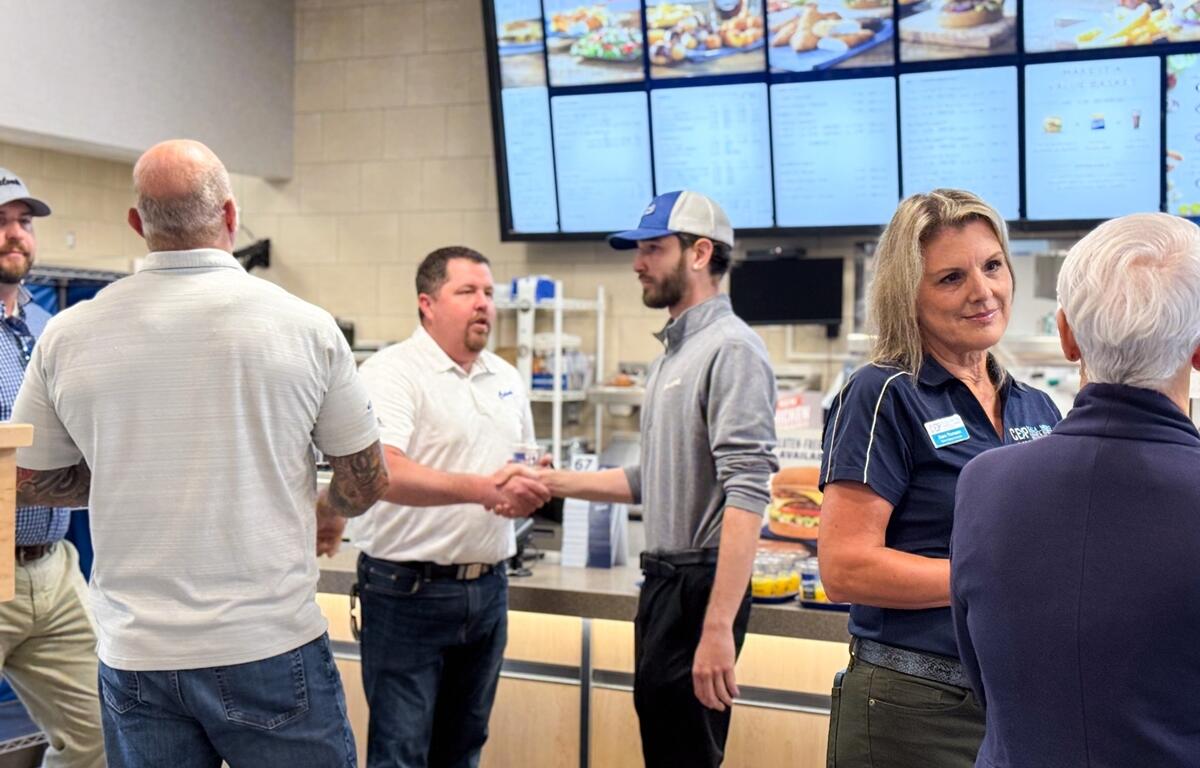 Culver’s employees and community members talk and shake hands inside the newly opened Ocala restaurant during its grand opening.