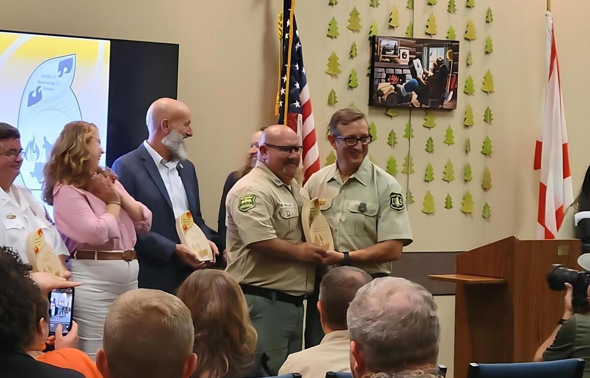 Richard Grajek with the Waccasassa Forestry Center ccepts a wildfire prevention award from a USDA official.