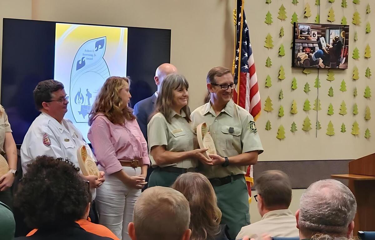 District Ranger Carrie Sekerak from the Forest Service receives an award during a ceremony at the library.