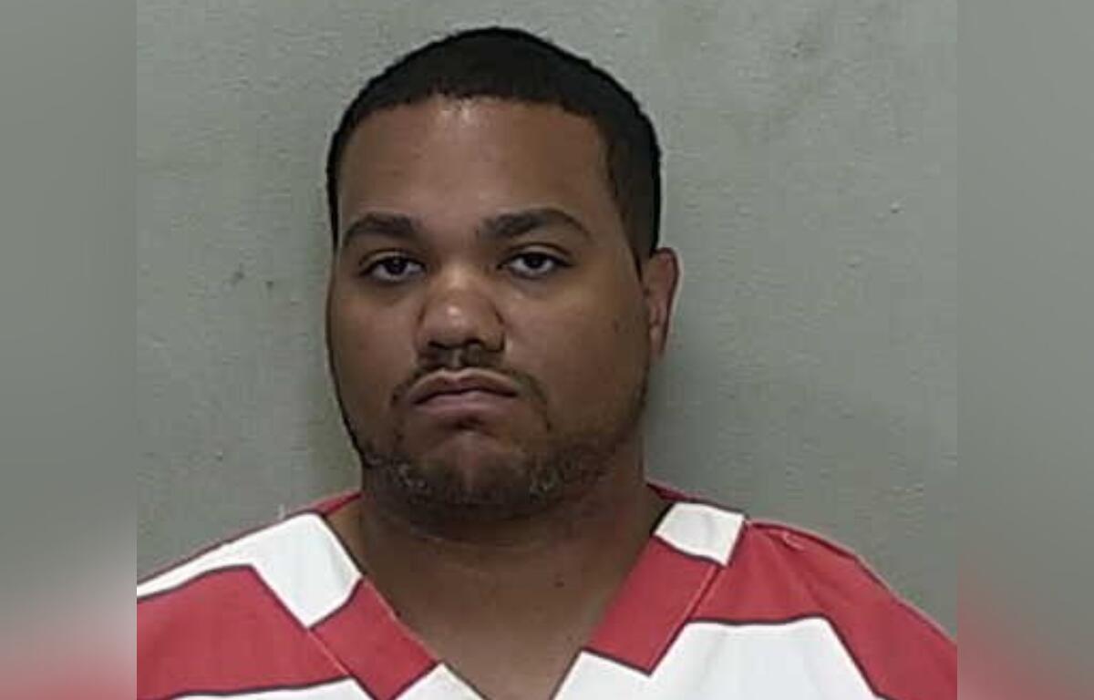 Mugshot of John James Sales, 29, wearing a red and white jail uniform following his arrest