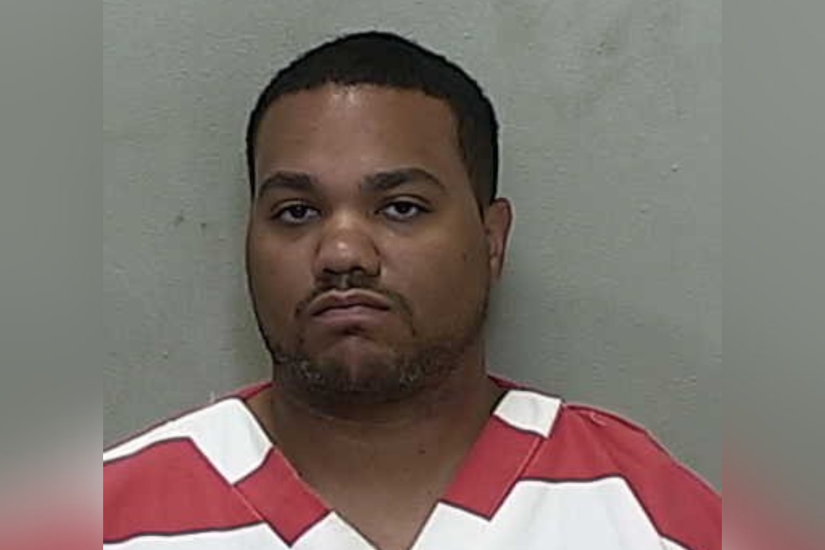 Mugshot of John James Sales, 29, wearing a red and white jail uniform following his arrest